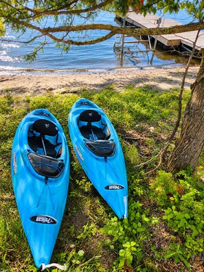 Deux kayaks sont garés sur une pelouse, près d’un quai.