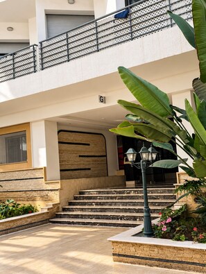 A multi-level building with a staircase leading to a gated entrance. - Ideal, 2 bedrooms, 2 bathrooms, fiber optic internet, IPTV, parking, fitness (Dar-el-Beida)