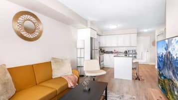 A modern apartment with a living room, a dining area, and a kitchen.