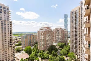 A high-rise residential building complex with multiple apartment buildings, surrounded by greenery and a clear sky. - Stylish 2+1 Condo | Views Near SQ1 Mall (Mississauga)