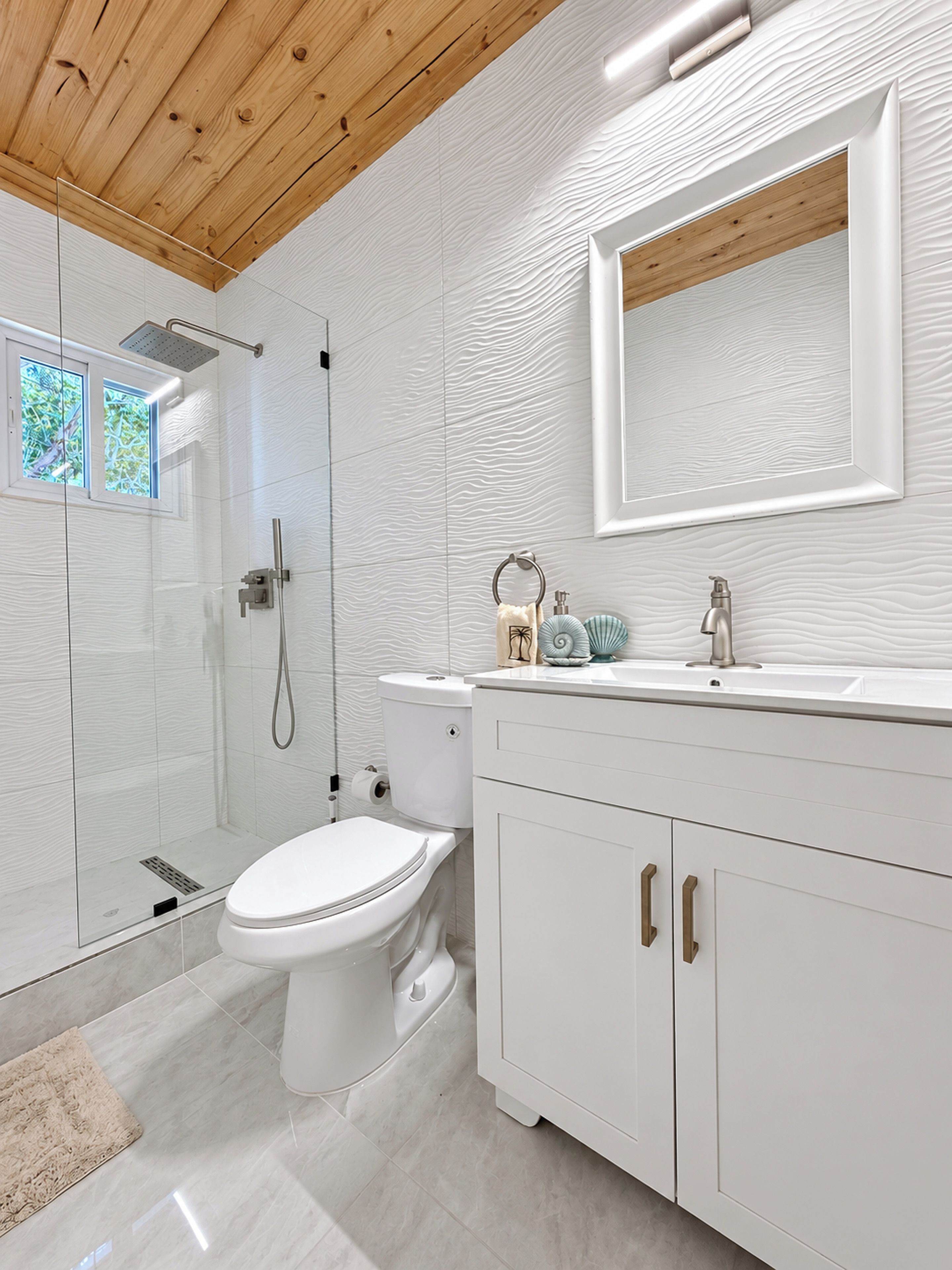 A modern bathroom with a shower, toilet, and vanity.