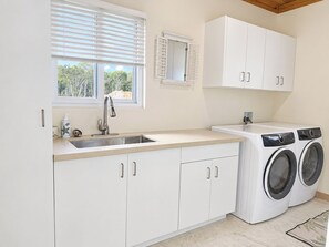 A kitchen with a built-in washing machine, a sink, and cabinets.