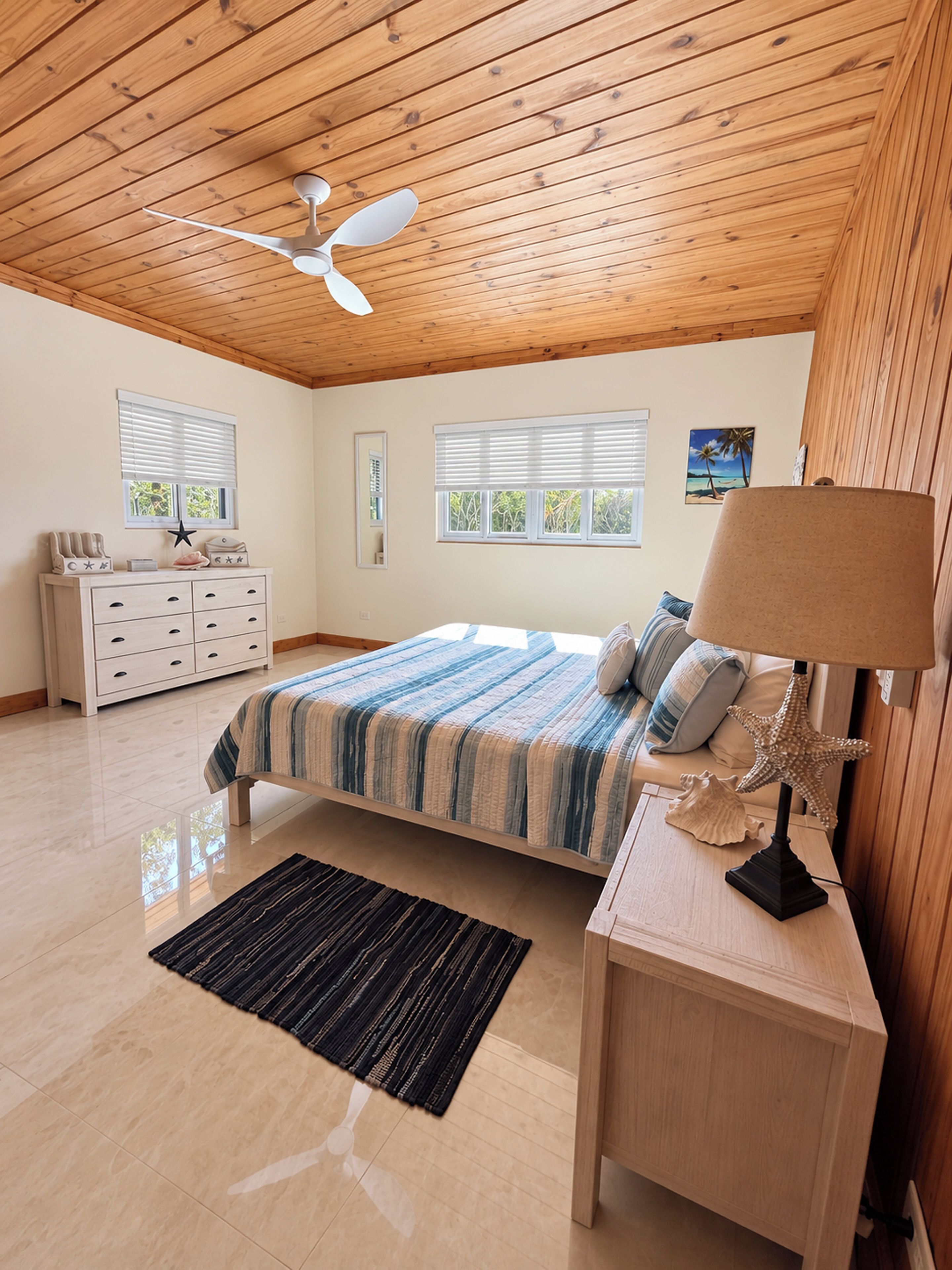 A bedroom with a bed, nightstand, dresser, and a ceiling fan.