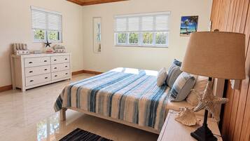 A bedroom with a bed, nightstand, dresser, and a ceiling fan.