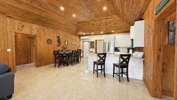 Un interior de madera con comedor, cocina y un letrero que dice 'Mermaids'.