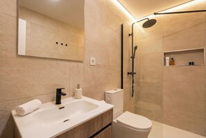 Ein modernes Badezimmer mit Waschbecken, Toilette und Dusche.