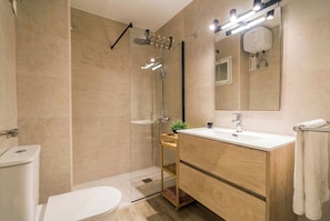 A modern bathroom with a glass-enclosed shower, a wooden vanity with a mirror, and a white toilet. - Elegant Stay La Naval 2 (Las Palmas de Gran Canaria)