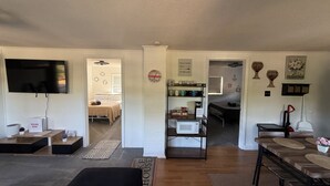 Un salon moderne doté d’un téléviseur à écran plat, d’un coin bar et d’un espace repas avec un banc.
