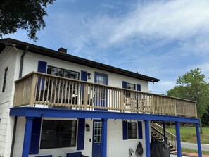 A two-story building with a balcony, a door labeled '115', and a visible outdoor area. - Cozy Apartment Flip-Flop up to the Lake Marina + Outdoor Fun (Mooresville)