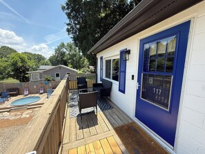 A deck with outdoor furniture, a pool, and a house with a blue door. - Cozy Apartment Flip-Flop up to the Lake Marina + Outdoor Fun (Mooresville)