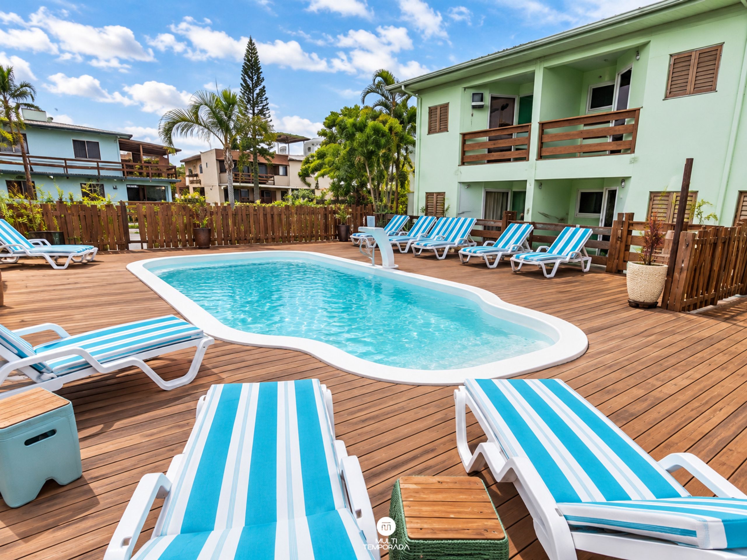 A swimming pool with lounge chairs and a wooden deck.