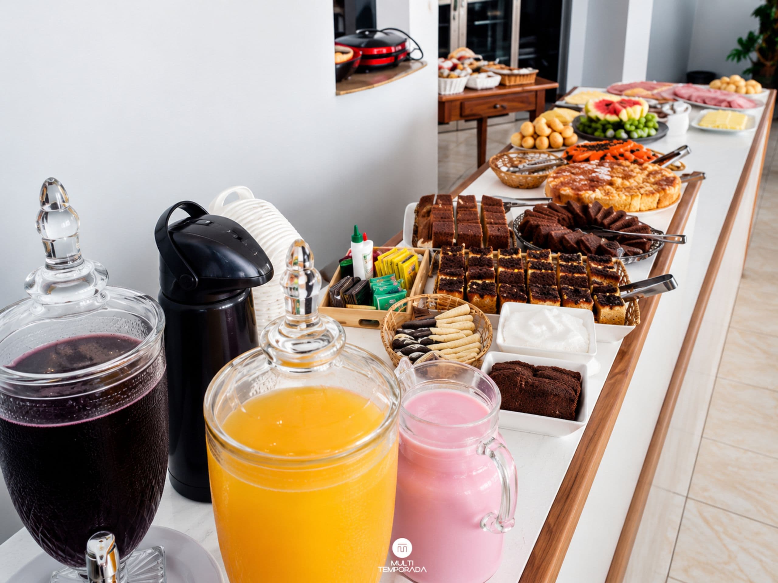 A buffet table with various food items and beverages.