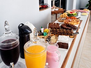 Uma mesa de buffet com diversos alimentos e bebidas.