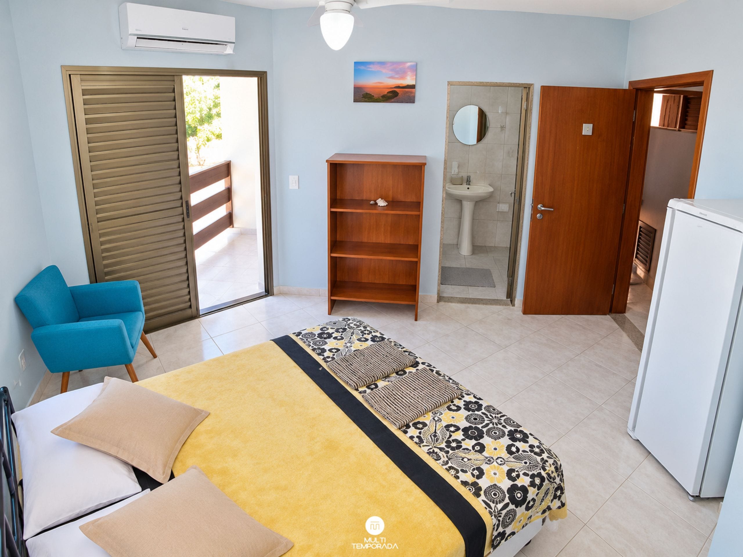 Une chambre à coucher comprenant un lit, une armoire, un bureau, une chaise, une salle de bain et un réfrigérateur.