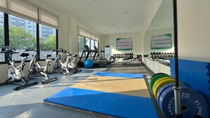 Une salle de sport équipée de machines d’exercice, de tapis et de poids.