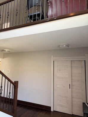 A staircase with a wooden handrail and metal balusters, leading to a landing with a white ceiling and a light fixture. - Beautifull Luxury House by Canion Meadows Golf Course (Calgary)