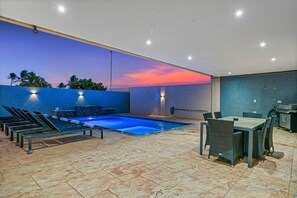 An outdoor pool area with lounge chairs and a dining table. - 2BR Aruba Getaway w/ Pool & BBQ, Near Eagle Beach (Oranjestad)