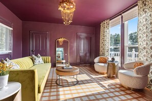 A room with a checkered floor, a green sofa, a round coffee table, and a large mirror. - Everett Estate | Modern Luxury Meets Historic Charm (Nellysford)