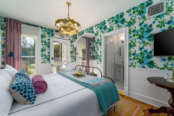 A bedroom with a bed, bedside table, and a TV.