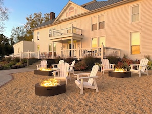 A house with a covered porch, outdoor seating, and a fire pit area.