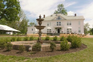 A large white building with a fountain in the front yard. - Everett Estate | King Suite + Covered Porch (Nellysford)