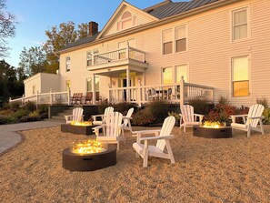 A house with a covered porch, outdoor seating, and a fire pit area. - Everett Estate | Mountain View King + Jacuzzi (Nellysford)