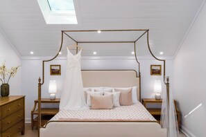 A bedroom with a canopy bed, bedside lamps, a dresser, and framed pictures on the walls. - Everett Estate | Private Loft + Mountain Views (Nellysford)