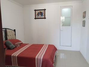 A bedroom with a bed, a door, and a wall-mounted picture. - Guelaguetza Terrace House, Oaxaca—10 minutes from downtown, ideal for families. (Oaxaca de Juárez)