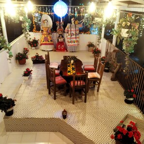 A dining area with a table and chairs, surrounded by potted plants and decorative elements. - Guelaguetza Terrace House, Oaxaca—10 minutes from downtown, ideal for families. (Oaxaca de Juárez)