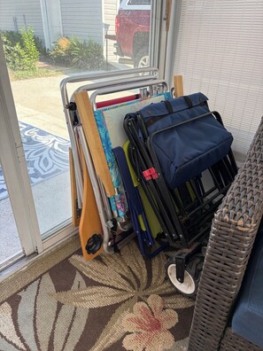 Un carro de equipaje con un tapete y una silla de mimbre en una habitación con alfombra estampada.