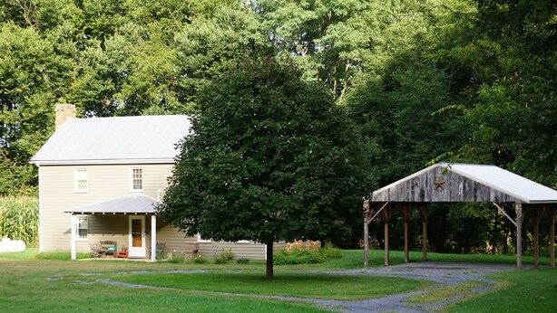 A house with a porch and a covered outdoor area. - Secluded 2-bedroom house with PRIVATE RIVER ACCESS - Petersburg, WV (Petersburg)