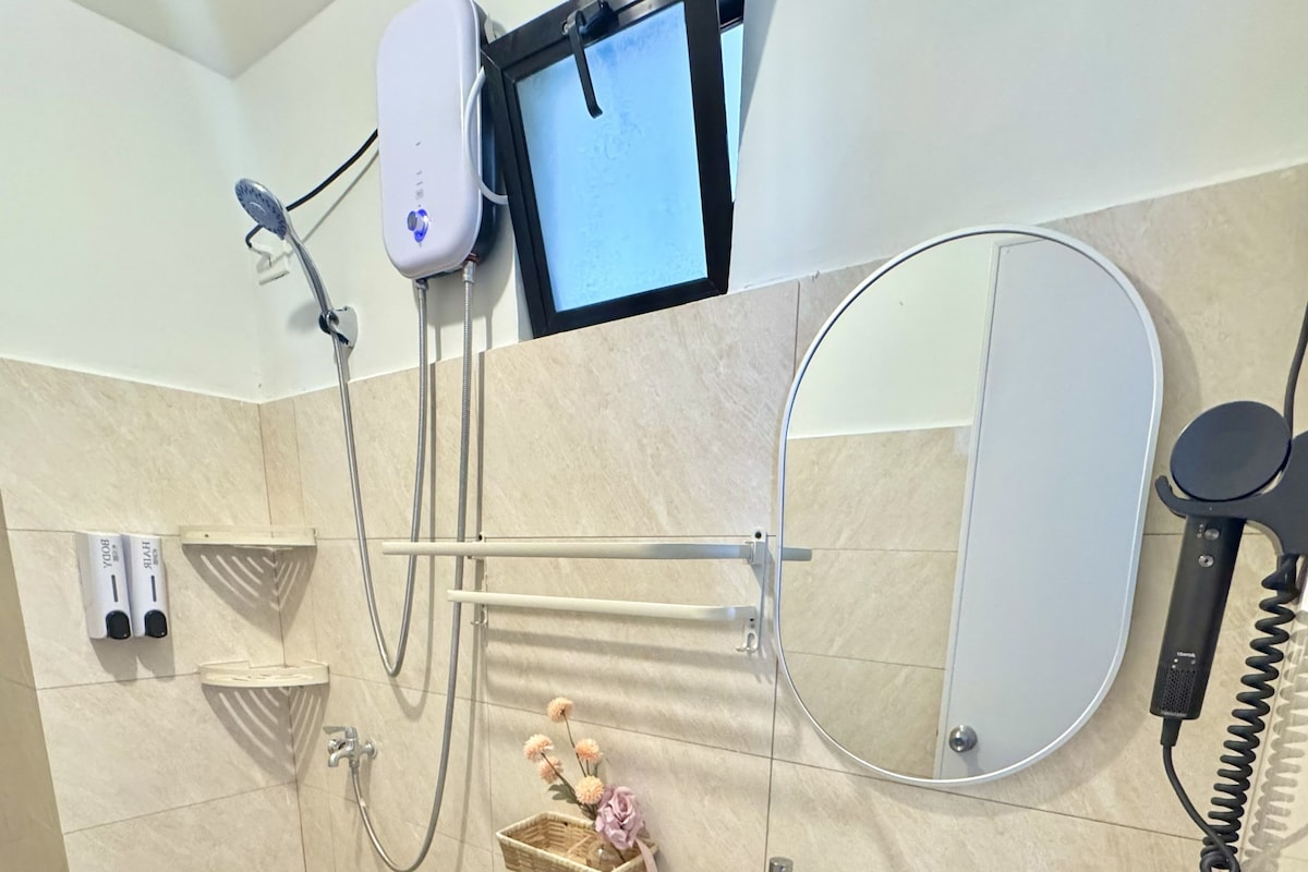 Bagno con WC, lavandino, doccia e televisore a parete.