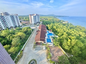 Una zona residenziale con piscina, parcheggio e vista sul mare.