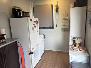 A compact kitchen with a refrigerator, microwave, and a small countertop.