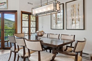 A dining room with a large wooden table, six chairs, a decorative bowl, and framed artwork on the walls. - Spacious 4BR Beaver Creek Ski In Ski Out Townhome (Beaver Creek)