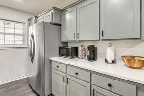 A kitchen with a stainless steel refrigerator, a microwave, a coffee maker, and a bowl on the counter. - Close to everything central 3/2 home (Galveston)