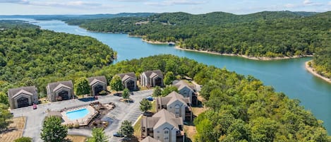 A residential area with multiple two-story houses, a swimming pool, and a river.