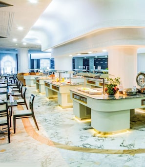 A spacious buffet area with multiple serving stations and a marble floor.