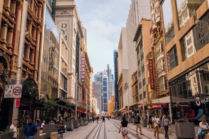 Una calle con edificios históricos, un tranvía y peatones.