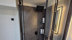 A modern bathroom with a glass-enclosed shower, a toilet, and a sink. - Stylish Studio Suite w/ Private Entrance | Parking (Brampton)