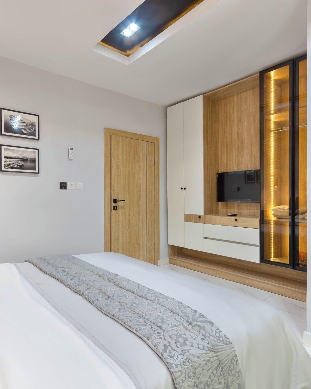 Ein Schlafzimmer mit einem Bett, einem Kleiderschrank, einem Fernseher und einer Deckenleuchte.
