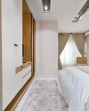 Ein Schlafzimmer mit Bett, Kleiderschrank, Spiegel und Deckenleuchte.