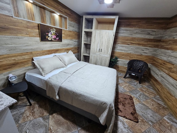A bedroom with a bed, bedside table, and a nightstand.