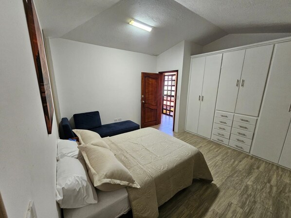 Un dormitorio con cama, armario y puerta que da a un espacio exterior.