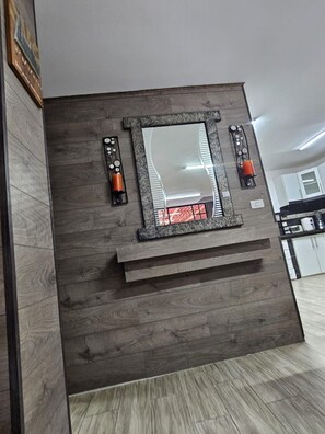 A modern kitchen with a built-in wooden cabinet, a central island, and a decorative mirror.