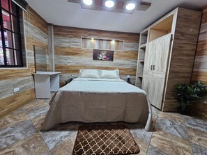 Un dormitorio con cama, mesitas de noche, armario y ventana.
