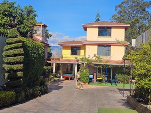 Un edificio de dos pisos con un patio cubierto y una piscina.
