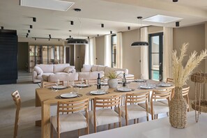 A dining area with a long wooden table set for six, surrounded by six wooden chairs with cushioned seats. - Luxury Villa Madora for up to 12 guests by Istrabook (Poreč)