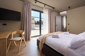 A hotel room with a bed, a desk, a chair, and a large window. - Luxury Villa Madora for up to 12 guests by Istrabook (Poreč)