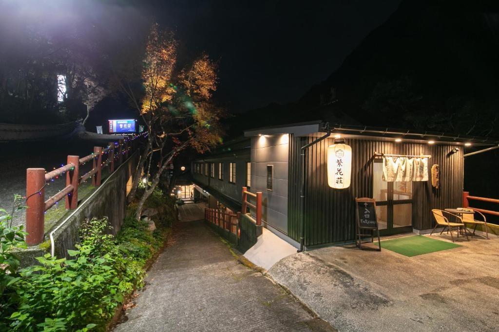 A narrow pathway leading to a building with a sign indicating a restaurant.